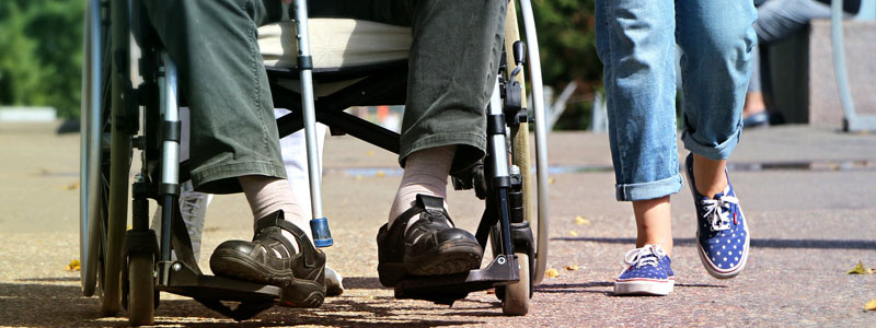 man with disability in wheelchair with cane