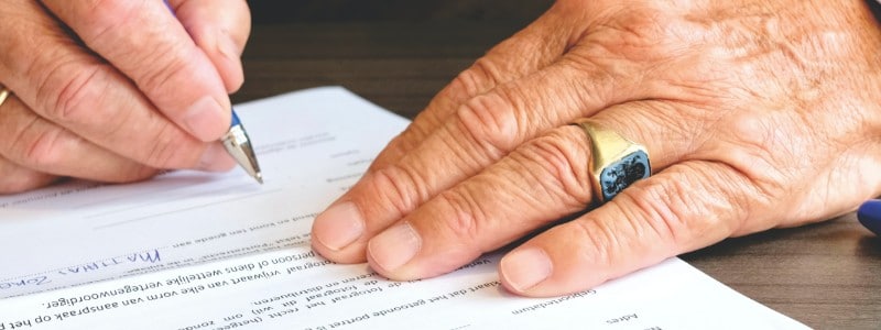 person preparing to sign a document