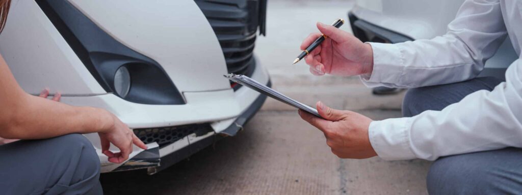 Insurance adjuster meeting with a minimally insured driver after a crash that may require help from an Indiana car accident lawyer