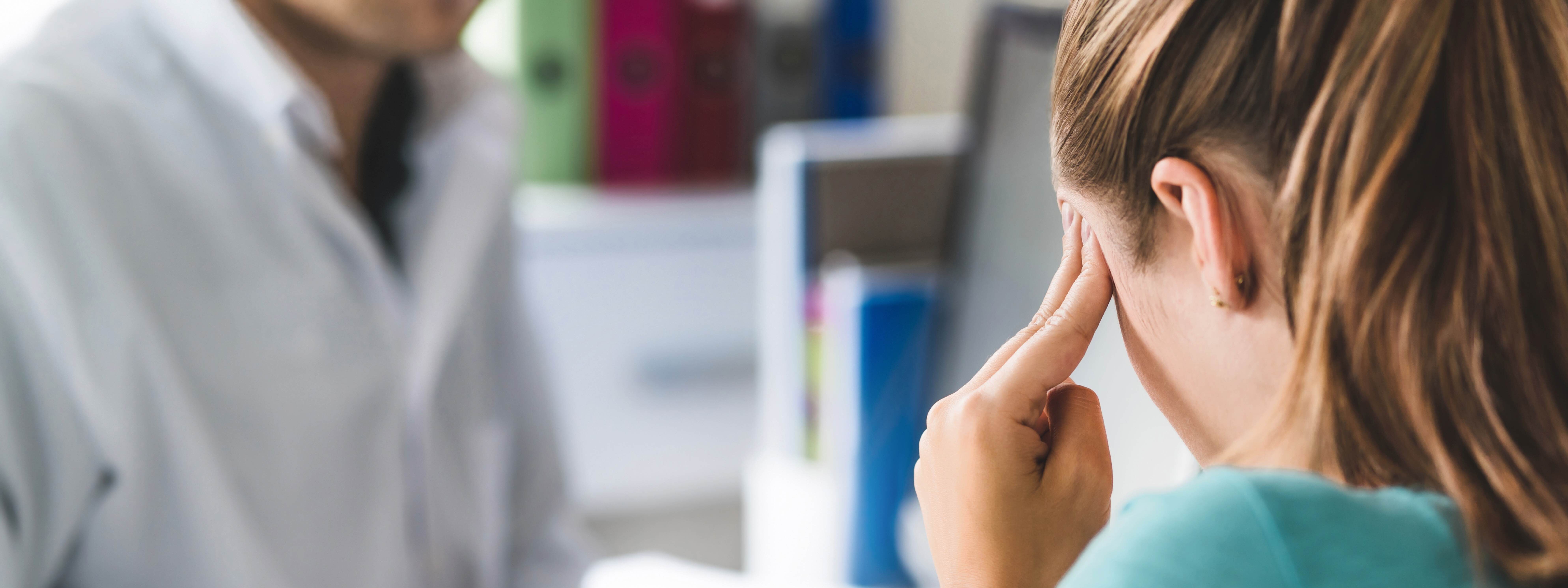 TBI patient discussing traumatic brain injury symptoms with a doctor